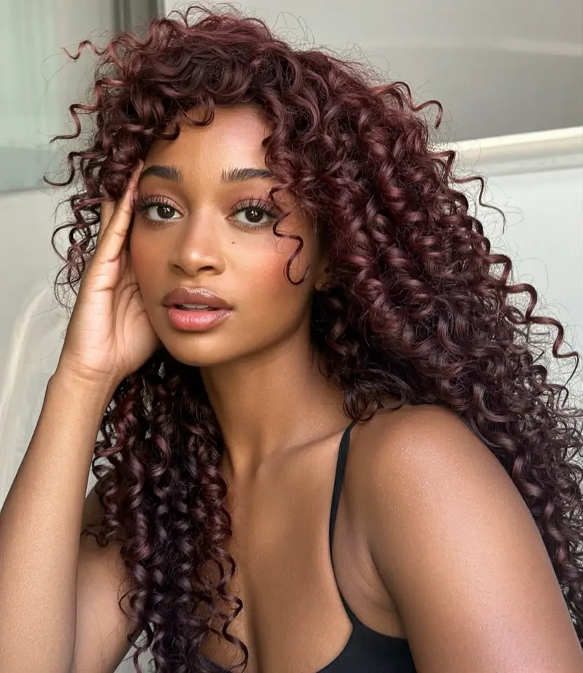 Fall 2025 Hair Colors ideas for Deep Skin Soft Burgundy Spiral Layers with Wispy Bangs