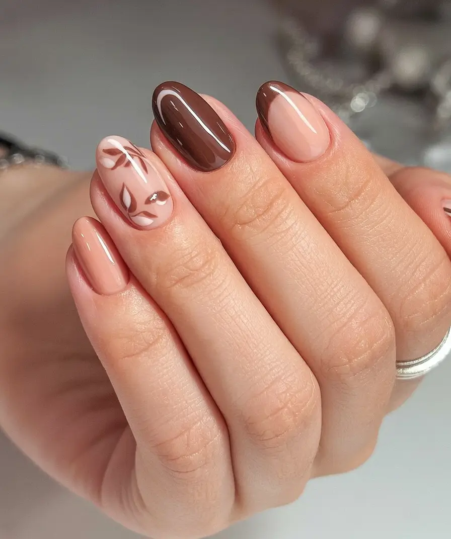 Stylish Fall Oval Shape Nail Designs 2025 Glossy Brown and Nude with Leaf Detailing
