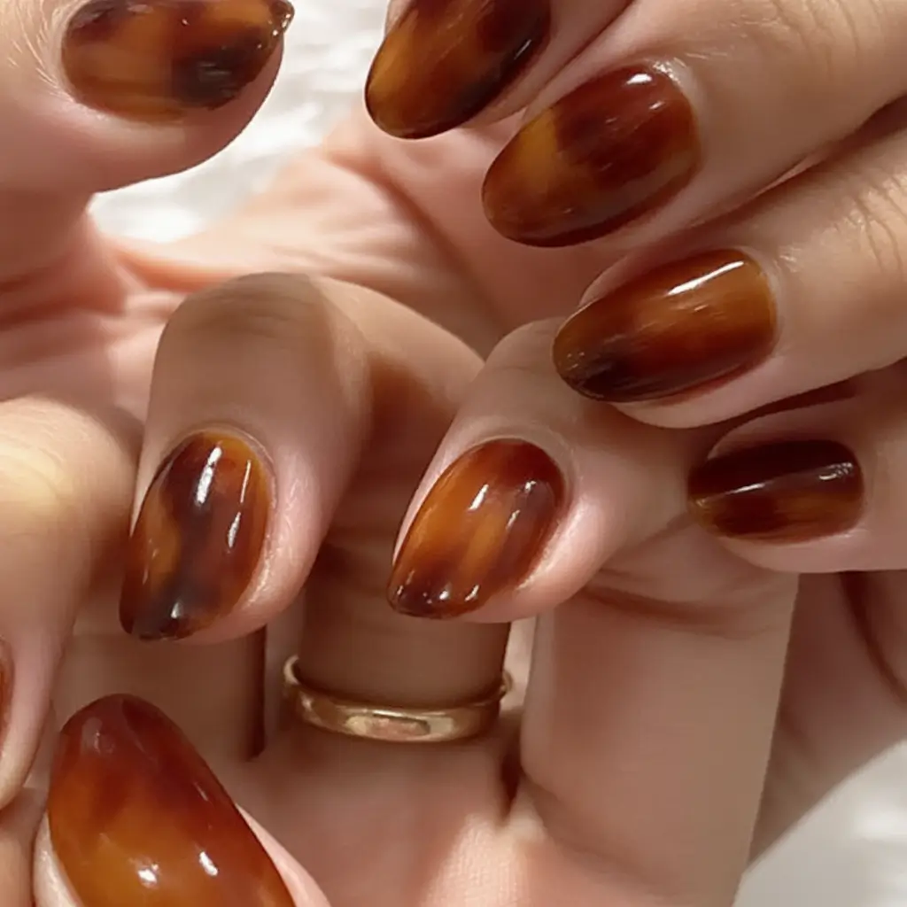 Stylish Fall Oval Shape Nail Designs 2025 Warm Brown Tones with Gold Foil Highlights